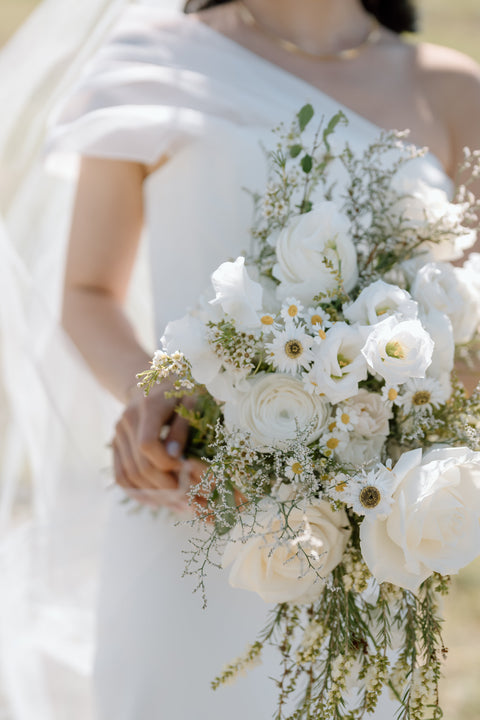 Elegant bridal bouquet featuring a vibrant mix of seasonal flowers, expertly arranged with lush greenery, perfect for a Colorado wedding. The bouquet complements the rustic charm and natural beauty of the mountain venue.