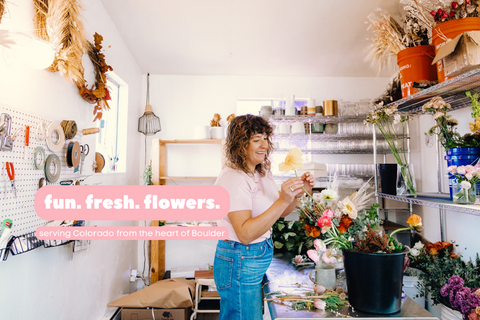 Ari, the owner of Arianna Floral Design, working creatively in her flower studio, surrounded by an array of vibrant and beautiful flowers, capturing the essence of her artistic and playful floral arrangements.