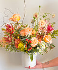 “The Main Character” medium Valentine’s Day flower arrangement by Arianna Floral Design in Boulder, Colorado, featuring peach roses, pink seasonal flowers, and textured greenery in a modern vase.