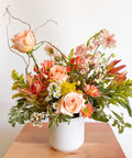 Close-up of “The Flirty Little Number” Valentine’s Day flowers arranged in a modern white vase, designed by Arianna Floral Design with peach roses, pink accents, and textured greenery in Boulder CO.
