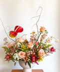 Wide shot of “The Grand Gesture” luxury Valentine’s Day arrangement with peach roses, pink focal flowers, and textured greenery, designed for Boulder CO flower delivery.